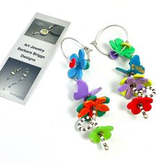 two pairs of earrings with colorful flowers on them next to a package for earwires