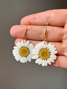 ➡️ [ITEM DESCRIPTION] Real wild white daisy flower, encased in UV resin. Average daisy flower has a 1" diameter. Lightweight, ultra white pedals, the perfect addition to any summer outfit. Earrings come in a variety of closures. See product specs below for more detailed information.  Metal closures and chain available in gold plated and stainless steel. All closures and chains are hypoallergenic and nickel / lead free. ➡️ [AVAILABLE STYLES] *Daisy Earring *Daisy Necklace  --- Custom Orders Accep White Daisy-shaped Jewelry For Spring, White Daisy-shaped Spring Jewelry, Spring White Birth Flower Jewelry, Mother's Day Birth Flower Earrings, White Daisy Flower Earrings For Spring, White Flower Charm Earrings, Summer White Flower Earrings With Flower Charm, White Flower Earrings With Summer Decoration, Summer Flower Earrings With Pressed Flowers