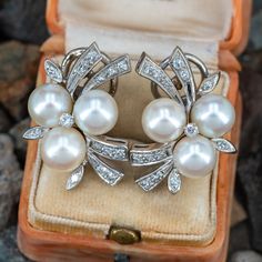 These beautiful vintage non-pierced clip-on earrings are each accented with one (1), prong set, round brilliant cut diamond, thirteen (13), bead set, round single cut diamonds and three (3), post set, cultured saltwater pearls. The earrings measure 25.6mm X 18.7mm. Luxury Classic Clip-on Earrings With 17 Jewels, Luxury Clip-on Pearl Earrings, Luxury Vintage Earrings With Prong Setting, Luxury Diamond Round Clip-on Earrings, Formal Clip-on Diamond Earrings Fine Jewelry, Formal Fine Jewelry Diamond Clip-on Earrings, White Gold Clip-on Diamond Earrings For Formal Events, Formal White Gold Clip-on Diamond Earrings, Formal Clip-on Diamond Earrings