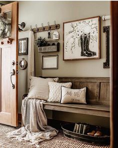 a wooden bench sitting next to a doorway with pictures on the wall above and below it