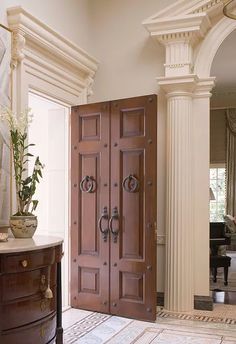 a large wooden door sitting inside of a living room