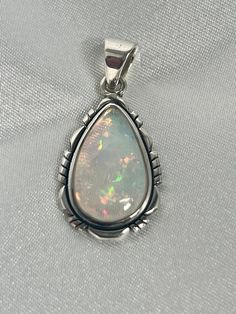 Embrace your best self with these magical Ethiopian Opal pendants. The brilliant southwest-styled setting and glowing teardrop stone make this exquisite pendant an excellent statement piece. Opals have been revered by many cultures for their unique mystical beauty and the belief that they protect against negative energy and soothe sadness. This lustrous pendant adds a touch of splendor to any outfit with its fiery hues. You won't be disappointed. Materials: .925 Sterling Silver, Ethiopian Opal A Southwestern Teardrop Gemstone Jewelry, Southwestern Style Teardrop Gemstone Jewelry, Spiritual Teardrop Pendant Large Jewelry, Bohemian Teardrop Jewelry With Large Stone, Bohemian Teardrop Large Stone Jewelry, Bohemian Cabochon Teardrop Jewelry, Traditional Teardrop Large Pendant Jewelry, Spiritual Teardrop Pendant Jewelry With Large Stone, Bohemian Teardrop Large Stone Necklace