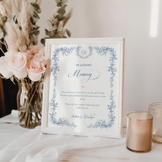 a table with flowers, candles and a framed memory card on it's side