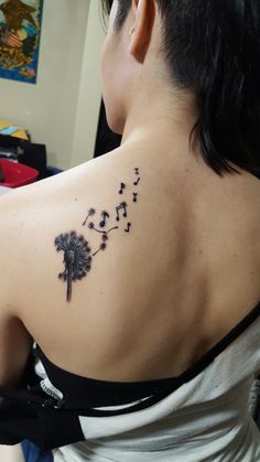 a woman with a dandelion tattoo on her back