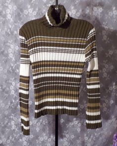 Item Details * Vintage late 90s turtleneck sweater * This is so classic 1996ish, pair it with some brown corduroy flares and you are ready to 90s out! * Army green, tan, and off white stripes * Chunky knit * Fold over turtleneck * 100% Acrylic * Made by Rave (amazing 90s and 2000s mall store) * Marked Size Medium * Very Good Vintage Condition: Item has been worn but no serious flaws to note. 90s Turtleneck, 2000s Mall, Corduroy Flares, Uni Outfits, Centre Commercial, Future Outfit, Womens Sweaters, Brown Corduroy, Striped Turtleneck