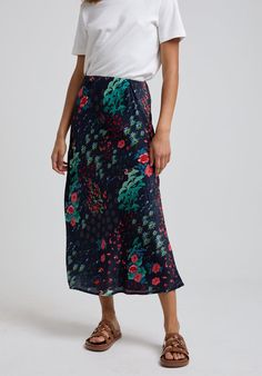 To create a feminine silhouette, the Ivy midi skirt is a stunning addition to your wardrobe. Boasting the Wonderland print, with floral hues in bold colour palette. A pull-on midi skirt with elasticated waist band; comfort sits alongside chic to make this the perfect all-rounder.   Wash and iron inside out. Wash with similar colours, reshape whilst damp. 100% Satin Sourced in India  Cool machine wash only. Wash inside out and with similar colours Elegant Printed Skirt, Elegant Midi Length Floral Print Bottoms, Elegant Printed Summer Skirt, Elegant Floral Print Maxi Skirt, Silk Flowy Skirt With Floral Print, Silk Floral Print Flowy Skirt, Silk Floral Print Midi Skirt, Silk Floral Print Skirt, Printed Relaxed Midi Skirt