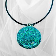 This beautiful circular glitter pendant necklace is crafted with precision using the finest quality resin and glitter, set in a 1-inch round stainless-steel setting, and finished with either a 20" silver-plated chain or a 20" black waxed necklace cord. Its vibrant green hue and sparkly finish will brighten up any outfit and make you stand out from the crowd. Ideal for special occasions.