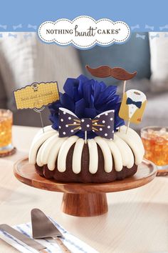 a bundt cake decorated with blue and white icing on a wooden platter