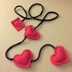 three felt hearts attached to black hair ties