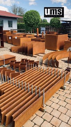 rows of wooden benches sitting next to each other on top of a brick floored area