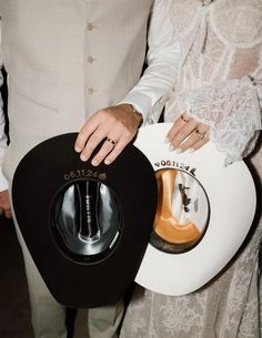 the man and woman are holding their hats