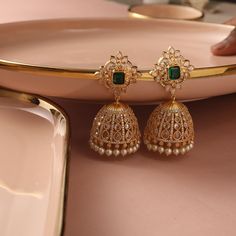 Description : Handcrafted with passion, these Sadie earrings feature CZ stones, exuding a mesmerizing sparkle. Nestled delicately at the bottom of each jhumka, the ethereal beauty of freshwater pearls adds a touch of grace and sophistication. Details & Specifications: Materials used: CZ stones with Yellow and White Gold Plating Weight - 44.03 gms Length - 6.5 cm Make it custom Want to make it custom earrings? Sure! Reach out to us at support@tarinika.com and we’ll be happy to make possible modif Jumkha Earrings Gold, Jumka Gold Designs, Jhumkas Gold Indian, Gold Jhumka Earrings Bridal, Jumkas Gold, Jhumka Designs Gold, Gold Jhumka Designs, White Stone Earrings, Necklace Set Indian Bridal Jewelry