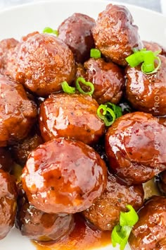 a white plate topped with meatballs covered in sauce