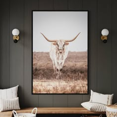 a long horn steer standing in a field framed on a wall above a wooden table