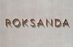 the name rokssanda is written in copper letters on a white stucco wall