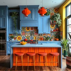 a kitchen with blue cabinets and orange stools in front of an island countertop