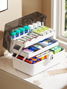 two white containers filled with different types of medicine on top of a counter next to a window