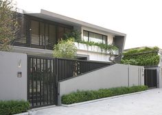 a modern house with an iron fence and gate