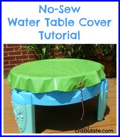 a table covered with a green and blue cover sitting on top of a wooden floor