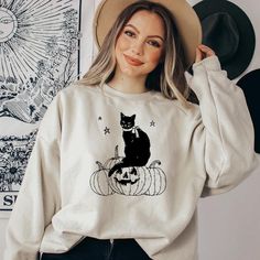 Cat Halloween Sweatshirt, Spooky Cats Halloween Hoodie, Halloween Sweatshirt, Cute Halloween Black Cat Sweatshirt,Cute Spooky Pumpkin Hoodie NOTE Black design for White, Sport Grey and Sand. White design for all other colors. Made with top-of-the-line vinyl and pressed with a professional grade heat press. "Hello there! 🌟 Welcome to our store, where we're thrilled to have you here. We specialize in custom design, printing, hand-pressing, and careful shipping of everything you see from our retail shop in New York. Our products are printed on high-quality apparel for your satisfaction. We offer 24/7 customer support, so feel free to reach out with any questions you may have. HOW TO ORDER: Please take a look at and review all the photos. Choose your Sweatshirt\Hoodie color. Select your Sweat Fall Long Sleeve Hoodie With Cat Print, Spooky Cat Design Tops For Fall, Casual Halloween Sweatshirt With Cat Design, Fall Crew Neck Sweatshirt With Cat Design, White Cat Design Sweatshirt For Fall, Casual Halloween Sweatshirt With Cat Print, Spooky Cat Print Tops For Fall, Spooky Fall Tops With Cat Print, Halloween Cat Print Crew Neck Sweatshirt