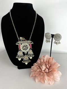 This unique tribal jewelry piece is perfect for a vibrant and fun look and is made in oxidized silver finish plating with matching earrings to go with the necklace. The Design is made of birds and Pink Stones for a splash of color on this modern sabyasachi piece along with beautiful matching earrings to go perfectly with the necklace! A vibrant and modern look for any event! This lightweight and elegant necklace is perfect for any bridesmaid, bride, sangeet or any occasion or event as a gift for Silver Peacock Design Jewelry For Party, Silver Necklaces With Matching Earrings For Festive Occasions, Bohemian Silver Meenakari Jewelry Sets, Silver Necklace With Matching Earrings For Festive Occasions, Festive Silver Necklaces With Matching Earrings, Festive Silver Necklace With Matching Earrings, Silver Metal Necklace With Peacock Design, Traditional Multicolor Jewelry Sets With Oxidized Finish, Silver Peacock Design Jewelry Sets For Festivals