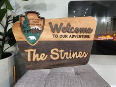 a wooden sign that says welcome to our adventure the strings