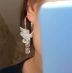 a close up of a person wearing some kind of earring with flowers on it