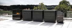 three black trash cans sitting on top of a white tile floor next to a fire pit