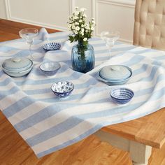 a blue and white table setting with flowers in a vase