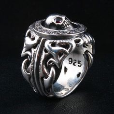 Tribal Garnet Skull 925 Sterling Silver Gothic Ring  Ring width : 7/8" x1" inch  Ring weight : 28 grams   Material:.925 sterling silver   Made of solid sterling silver and featuring a unique design engravings of a skull, this is a one of a kind ring. The center piece skull features two blood red garnet gemstone eyes. Solid and masculine in design, this ring is a must-have for your biker jewelry accessory collection.  It will hold up to years of wear and tear and will handle any road trip you hea Silver Symbolic Skull Ring, Symbolic Silver Skull Ring, White Gold Round Skull Ring Stamped 925, Sterling Silver Open Skull Ring, Symbolic Style, Symbolic Sterling Silver Open Skull Ring, Skull Ring Stamped 925 For Anniversary, 925 Stamped Skull Ring For Anniversary, Collectible Engraved Skull-shaped Rings, Silver Gothic Skull Ring