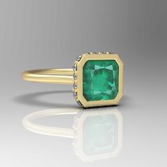 an emerald and diamond ring in yellow gold