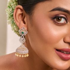 Description: Gorgeous and elegantly simple, these elegant CZ jhumka earrings add radiance to any outfit. Featuring an array of high-quality CZ stones set in 925 silvers in floral design, they shine beautifully. Style with a pastel-hued dress or an elegant silk saree to make the green center stone stand out. Product Information: Metal: 925 Silver with Gold & White Gold Plating Length: 7 cm Stones: High Grade CZ Stones Findings: Push back Festive Silver Jhumkas With Elegant Design, Cubic Zirconia Chandbali Jhumkas For Wedding, Cubic Zirconia Chandbali Jhumkas For Reception, Wedding Chandbali Jhumkas With Cubic Zirconia, Wedding Cubic Zirconia Chandbali Jhumkas, Elegant Jhumkas With Tilla Details, Elegant Tilla Jhumkas, Elegant Jhumkas For Diwali Reception, Elegant Cutdana Jhumkas For Diwali