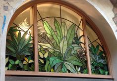 a stained glass window with green plants on it