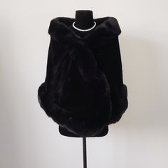 a mannequin with a black fur coat on it's head and a pearl necklace