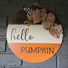 a sign that says hello pumpkin hanging on a brick wall