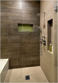 a walk in shower sitting next to a tiled wall