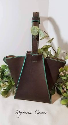 This is a hand-made hobo bag.  It is a unique shape and style.  The leather is 5-6 oz. thick.  It is beautiful brown leather with some teal accent.  This purse is fully hand stitched. Brown Bucket Shoulder Bag With Handles, Brown Bucket Bag With Top Handle And Pouch, Brown Hobo Bucket Bag With Removable Pouch, Brown Bucket Satchel With Handles, Brown Bucket Satchel For Errands, Brown Handheld Hobo Bag For Errands, Handheld Brown Hobo Bag For Errands, Brown Bucket Bag With Leather Lining, Handmade Brown Hobo Bag