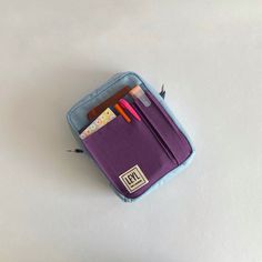 a purple pencil case with two pens and an eraser in it on a white surface