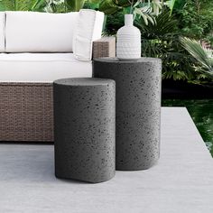 two concrete vases sitting next to each other on a patio