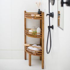 a wooden shelf in the corner of a bathroom