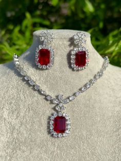 Handmade  Style: Necklace and Earrings Set Material: Platinum Plated, Lab Simulated Ruby and White Sapphire Stones Imported Please Note: This necklace and earrings are sold as a set. Item Number: 7078R Ruby Jewelry With Matching Earrings For Gift, Round Ruby Jewelry Sets For Gifts, Ruby Jewelry Sets For Gifts, Ruby Jewelry Set With Matching Earrings As A Gift, Ruby Jewelry With Matching Earrings As A Gift, Handmade Ruby Jewelry Sets In Elegant Style, Handmade Ruby Jewelry Sets, Elegant Ruby Jewelry Sets With Matching Earrings, Elegant Handmade Ruby Jewelry Sets