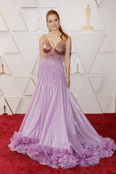 a woman in a purple gown on the red carpet at an oscars event,