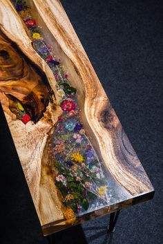 the table is made out of wood and has flowers painted on it's sides