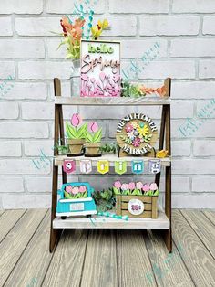 a wooden shelf with flowers and cards on it in front of a brick wall that says happy birthday