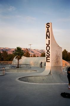 a skateboarder is doing a trick at the top of a half pipe in a skate park