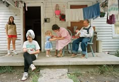 a group of people sitting on top of a porch