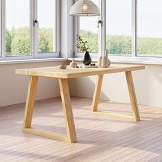 a wooden table with two vases on it in an empty room next to large windows