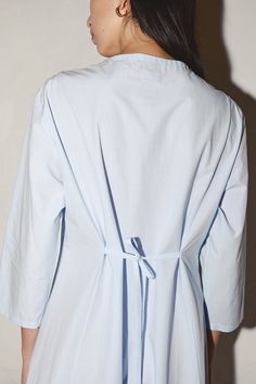 a woman wearing a light blue shirt dress