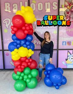 a woman standing next to a bunch of balloons