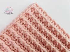 a pink knitted hat on top of a white surface with the words, crochet